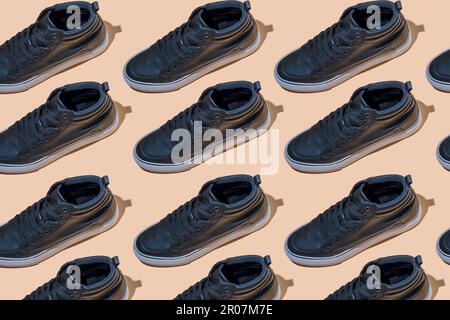 Modello del pattino. Scarpe nere su uno sfondo beige pastello vista dall'alto con ombra. Concetto di accessori. Nuove scarpe in pelle. Stile sportivo classico. Scarpa di moda. Pubblicità piatta minimalistica del negozio. Calzature. Foto Stock