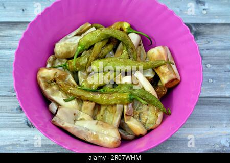 Melanzana fritta e peperoni verdi sott'aceto, aglio, peperoncino rosso, aceto, limone, coriandolo, prezzemolo, pomodori e spezie a pezzi, Foto Stock