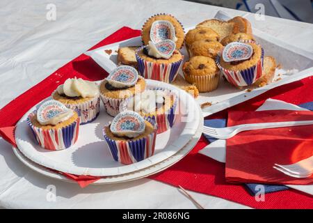 7th maggio 2023. Odiham, Hampshire, Inghilterra, Regno Unito. Il lungo fine settimana di festa per l'incoronazione di re Carlo III e la regina Camilla continuò con una grande festa di strada lungo la High Street villaggio, che è stato decorato con concia rosso bianco e blu. È stato un pomeriggio di sole per l'evento popolare, che ha attirato molte persone a celebrare l'occasione reale. Primo piano di torte fata decorate per l'incoronazione. Foto Stock
