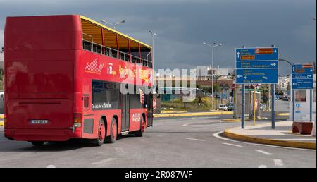 Porto di Heraklion, Creta, Grecia, UE. 2023. Autobus turistico ponte doble rosso che passa le indicazioni stradali su ite route intorno alla città di Heraklion, Creta. Foto Stock