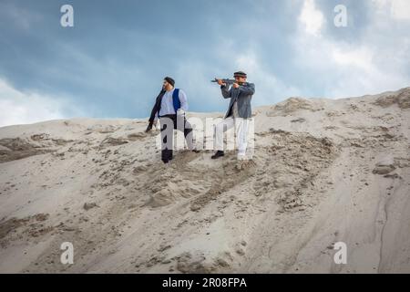 I talebani stanno pianificando attacchi terroristici con armi. Soldato maschio arabo in un headdress fatto del keffiyeh nazionale con le armi nelle sue mani. Foto Stock