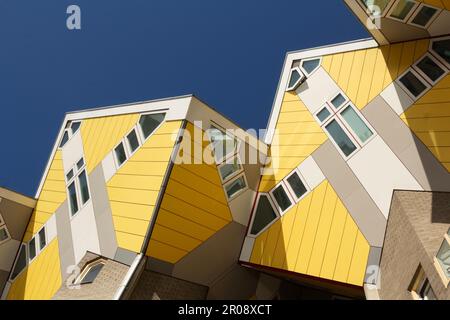 Rotterdam, NL, le case a cubo giallo, o Kubuswoningen, in Overblaak Street, formano motivi geometrici contro un cielo blu. Foto Stock