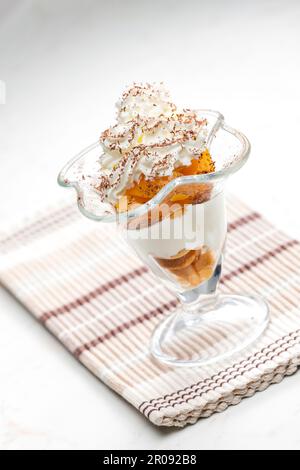 gelato con pesca stufata e panna montata Foto Stock