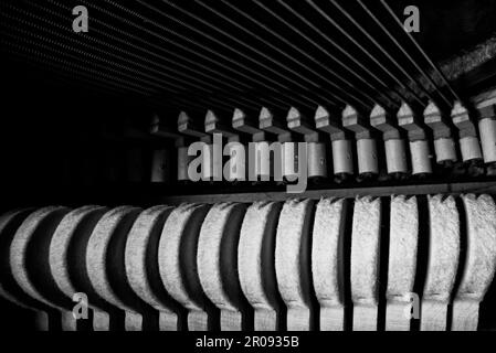 All'interno del pianoforte. Vista ravvicinata dei martelli e delle corde all'interno del pianoforte verticale. Foto Stock