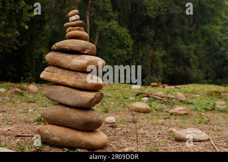 Le pietre di ciottoli sono impilate in una piramide contro lo sfondo naturale, il concetto di armonia di equilibrio e meditazione Foto Stock