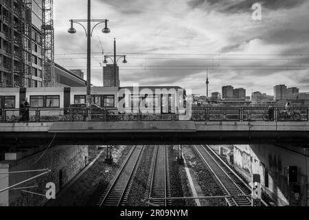 Un tram che passa sopra Warschauer Brücke (ponte Warschauer) con la torre della televisione sullo sfondo, Warschauer Strasse, Friedrichshain, Berlino, Germania Foto Stock