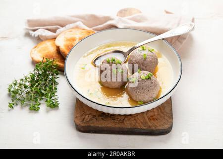 Canederli o Knodel in brodo con cipolla verde, pasta tipica o gnocchi per le Alpi, Alto Adige, cucina tedesca, italiana, austriaca. In bre obsoleto Foto Stock