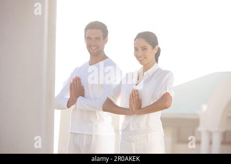 Pace perfetta alla luce del sole. un giovane uomo e una donna che fanno yoga all'aperto. Foto Stock