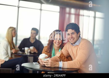 Theyre una coppia così carina. Una giovane coppia felice in un appuntamento in una caffetteria. Foto Stock