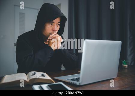 Christian concetto di tecnologia online. Mani che pregano cristiano con computer portatile digitale, chiesa online dal vivo per il servizio domenicale. cattolico asiatico ma Foto Stock
