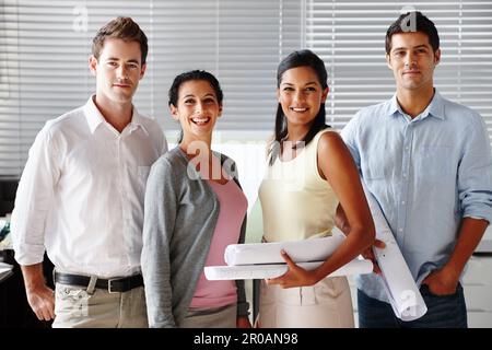 Team di architetti di successo. Un team sicuro di architetti sorridenti mentre si tengono progetti. Foto Stock