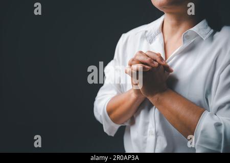 La vita cattolica cristiana crisi la preghiera a dio. Donna prega dio per la benedizione di desiderare avere una vita migliore. Le mani della persona pregano dio. Implorando per f Foto Stock