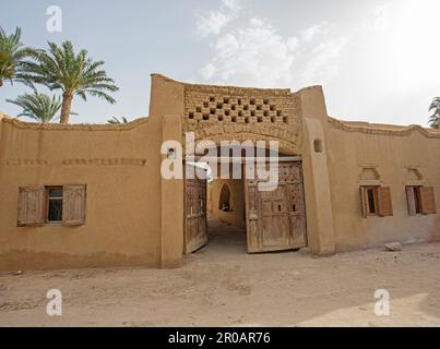 Vecchio rustico cancello d'ingresso porta in legno in muro di tradizionale mattoni di fango casa egiziana Foto Stock
