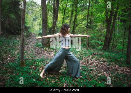 Una giovane donna pratica lo yoga sportivo in natura Foto Stock