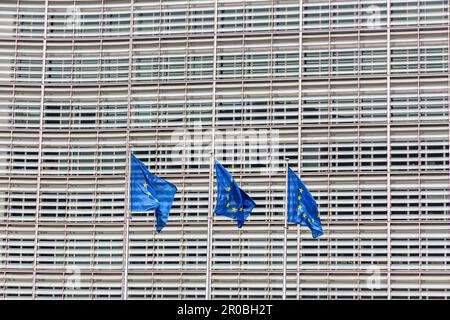 Tre bandiere dell'Unione europea sventolano davanti alla facciata del Berlaymont, sede della Commissione europea a Bruxelles. Foto Stock