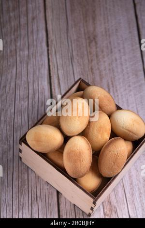 fotografa un sacco di noci con latte condensato su uno sfondo di legno Foto Stock