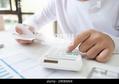 Uomo d'affari che utilizza una calcolatrice che analizza il grafico degli investimenti sul Foto Stock