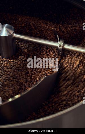 Un vassoio di raffreddamento raffredda il caffè appena tostato da un torrefore. Foto Stock