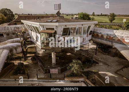 Una vista inquietante di una torre di controllo abbandonata, con aerei in decadenza per quanto l'occhio può vedere. Foto Stock