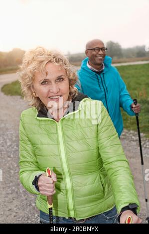 Coppia senior escursioni con pali escursionistici, Baviera, Germania Foto Stock