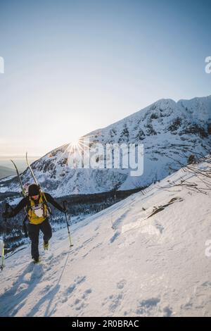 L'escursionista maschile sale verso la cima innevata di Katahdin all'alba Foto Stock