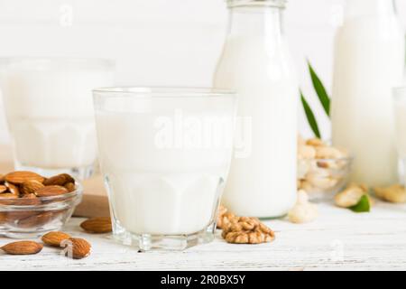 Set o raccolta di vari latte vegano mandorla, anacardi, su sfondo tavolo. Latte vegetale vegano e ingredienti, vista dall'alto. Foto Stock