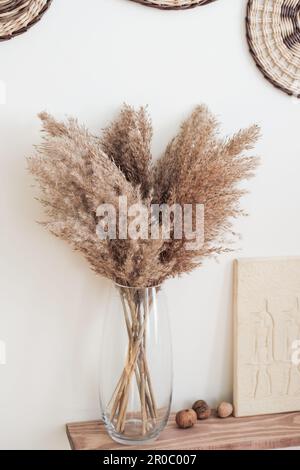 bouquet di erba pampas in vaso di vetro trasparente su scaffale. design degli interni moderno e alla moda. Foto Stock