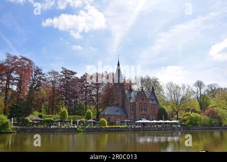 Vecchia chiesa che si riflette nell'acqua a Minnewaterpark, Bruges, Belgio Foto Stock