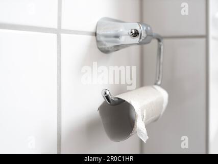 rotolo di carta igienica vuoto sul porta salviette per bagno, che si esaurisce nel concetto di carta igienica Foto Stock