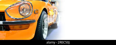 Dettaglio fari anteriori di auto classica arancione, sfondo bianco, lato banner, spazio copia Foto Stock