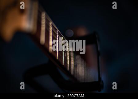 Primo piano del collo della chitarra elettrica al fondo del supporto per chitarra Foto Stock