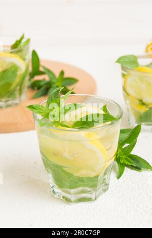 Mojito cocktail. Rinfrescante cocktail mojito con lime, limone e menta in un bicchiere alto con un bastone. Foto Stock