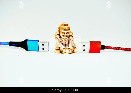 Connettiti e Chatta. Cavi usb rossi e blu e Buddha figurine Foto Stock