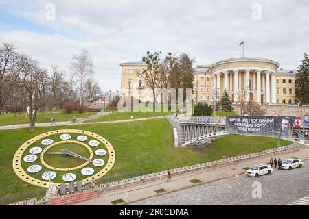 Kyiv, Ucraina - 03.27.2023: Ponte con poster e Galleria dei ritratti per la memoria di Eroi del Cielo cento, memoriali, orologio, Palazzo della cultura a Maidan Foto Stock