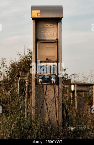 Una pompa a gas in stile antico è isolata in un campo d'oro di alte erbe, situato in un'area remota Foto Stock