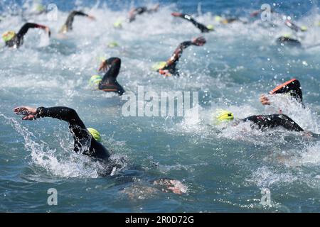 Gli atleti di nuoto in una gara di triathlon nel mare.gli uomini nuotatori strisciano in mare blu, corsa per il triathlon Foto Stock