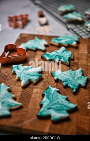 Una scena festiva di biscotti di Natale modellati in un albero di Natale, decorato con un motivo verde batik Foto Stock