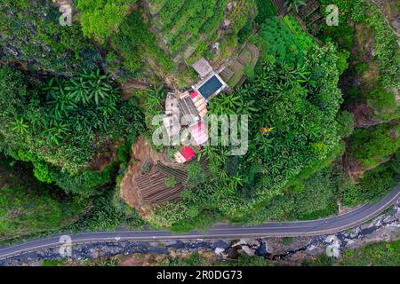 Vista aerea di una casa tradizionale con giardino familiare vicino a una strada in una remota valle verde vicino al villaggio XOXO sull'isola di Santo Antao a Cabo verde Foto Stock