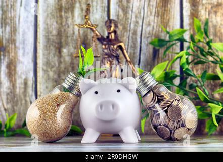 Simbolo della legge e della giustizia, piggy bank, monete all'interno della lampadina, pianta che cresce all'interno della lampadina. Eco-verde energia rinnovabile concetto. Foto Stock