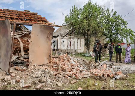 Komyshevakha, Ucraina. 08th maggio, 2023. I residenti locali si trovano accanto a un edificio che è stato gravemente danneggiato di notte, a seguito di conchiglie russe. Un funzionario ucraino ha affermato che alcune truppe russe stanno cercando di lasciare Zaporizhzhia travestita da civili in mezzo alle evacuazioni in corso dalla regione meridionale, che potrebbe essere un obiettivo della controoffensiva prevista dall'Ucraina. Credit: SOPA Images Limited/Alamy Live News Foto Stock