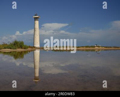 Faro riflesso sull'acqua, palude di sale di Jandia, costa di Morro Jable, Fuerteventura Island, Spagna Foto Stock