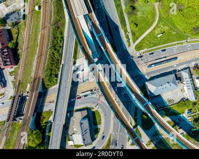 Incrocio multilivello di strade, strade, tram e ferrovie in varie direzioni con la stazione ferroviaria di Cracovia Podgorze su un nuovo viadotto. Vista aerea Foto Stock