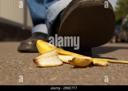 Persona intorno a scivolare su una buccia di banana o buccia di banana Foto Stock