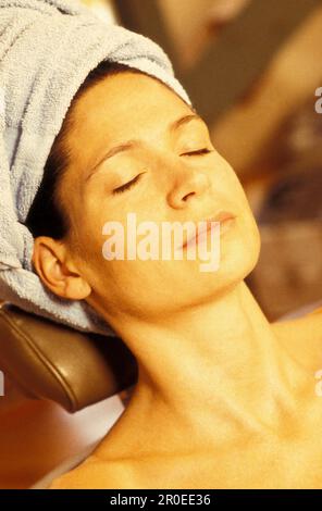 Donna che indossa un asciugamano sulla testa rilassante, Vienna, Austria Foto Stock