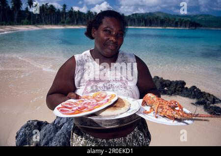 Woman, Lobster, Beach, Woman offre aragosta in un bar sulla spiaggia a Playa Rincon, Las Galeras, Penisola di Samana, Repubblica Dominicana Foto Stock