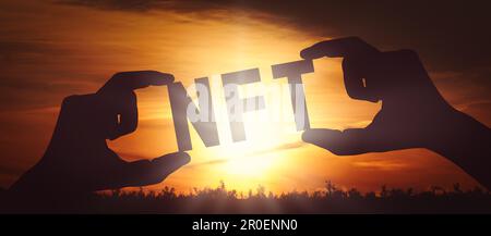 NFT - mani umane che tengono nero silhouette parola Foto Stock