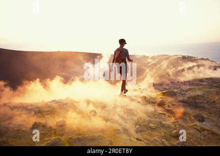 Persona che cammina attraverso il vapore di zolfo, Caldera, Gran Cratere, Vulcano, Isole Eolie, Italia Foto Stock