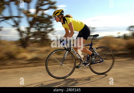 Donna su una bicicletta da corsa nel Joshua Tree National Park, California, USA Foto Stock