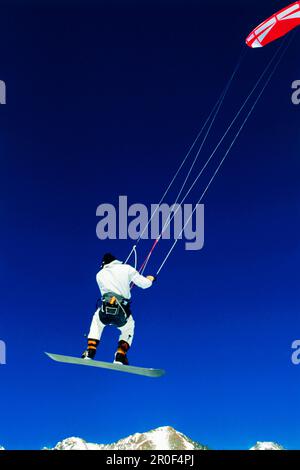 Uomo kiteboarding nella neve, Lermoos, Lechtaler Alpen, Tirolo, Austria Foto Stock