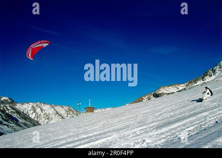 Uomo kiteboarding nella neve, Lermoos, Lechtaler Alpen, Tirolo, Austria Foto Stock